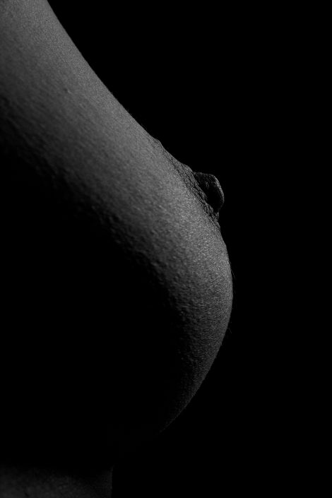 Sideview of a womans breast in black and white