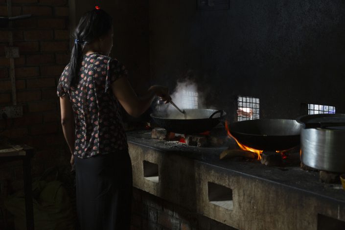 Woman cooking on a woodfire in a restaurant in Ngapali, Shan State, Myanmar